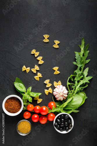 Ingredients for italian farfalle pasta. Recipe. Raw materials for cooking on a black background