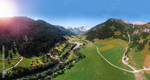 Beautiful aerial wide view on mountain city. Summer sunny day, Wasserfall Erlebnisweg river lake and buildings. Entrance to the wildpark at the Grossglockner High Alpine Road in Ferleiten, Austria. photo