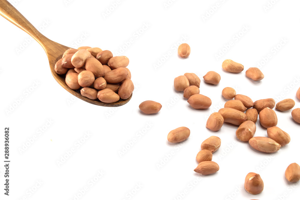 Peanuts in a wooden spoon And some are scattered isolated on a white background Peanuts in a wooden spoon And some are scattered isolated on a white background