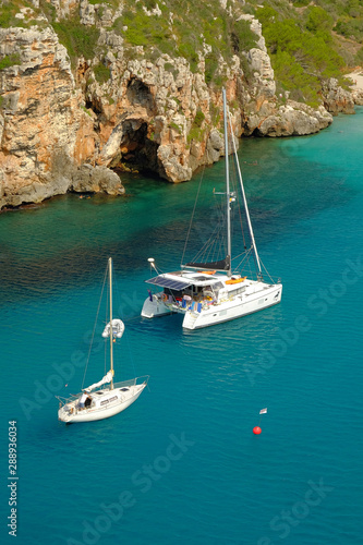 View on white boats on the beach Cala en Porter, Menorca.