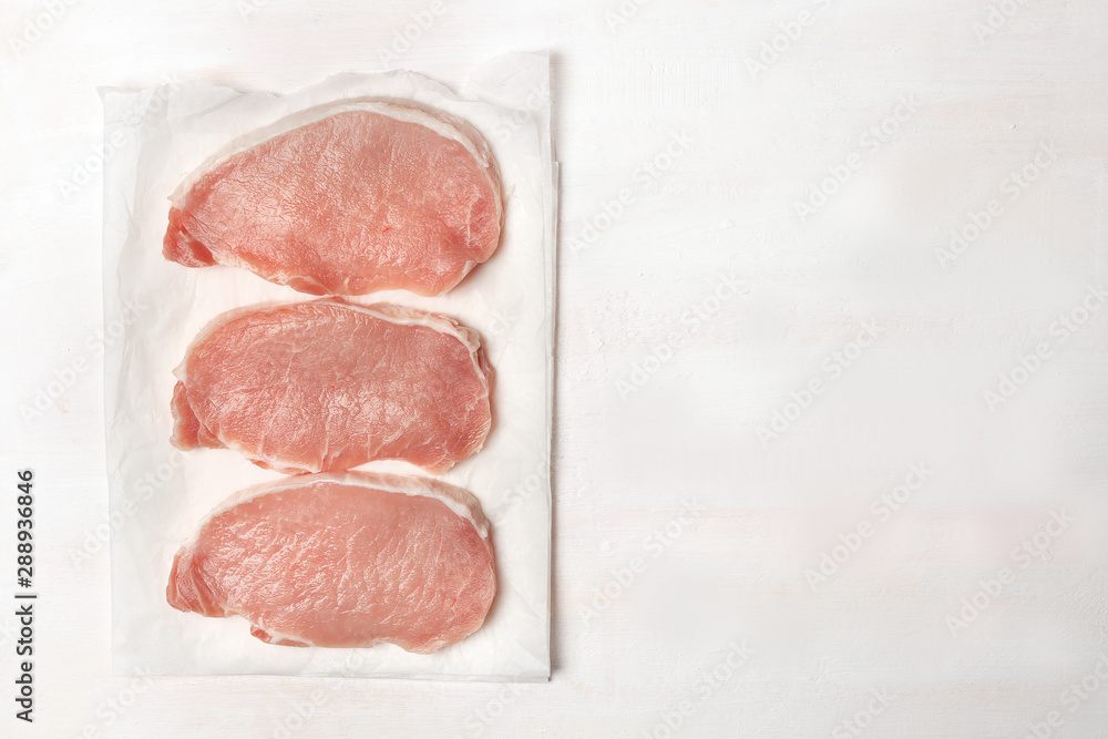 Pieces of pork loin. Raw meat on parchment.On white background. BBQ Pieces of pork loin. Raw meat on parchment.On white background. BBQ
