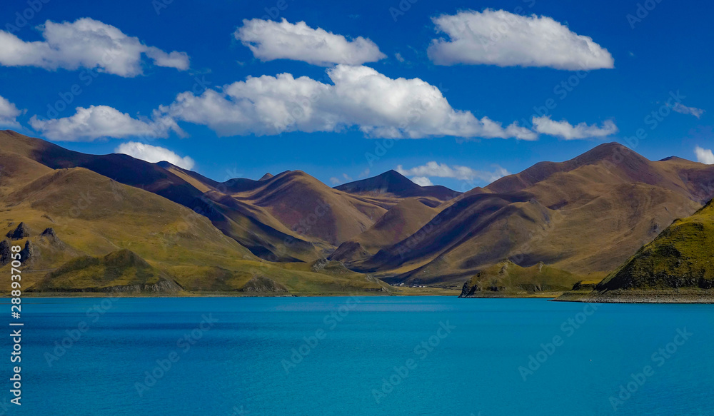 AERIAL: Spectacular shot of the mountainous landscape surrounding Yamdrok lake.