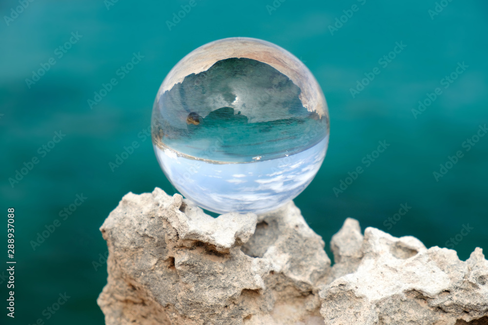 Fototapeta premium Crystal ball on the rock on the blue background.
