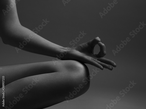 Yogi woman practicing yoga lesson, breathing, meditating, doing Ardha Padmasana exercise, Half Lotus pose with mudra gesture, working out, indoor close up. Well being, wellness concept