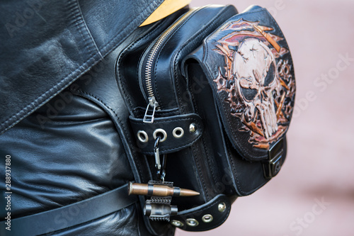 Leather goods: bags, purses, purses are on the trading table in the market of handmade products.Top view of leather wallet with money on wooden table. Leather craft.Biker theme.