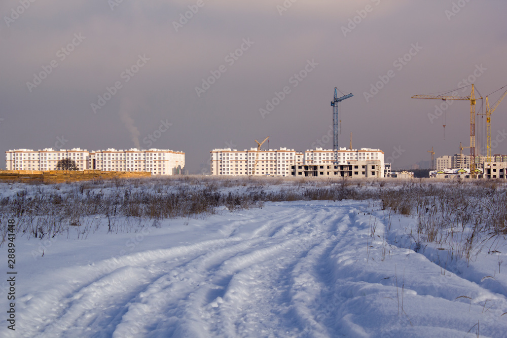 Winter road under snow with city view in background