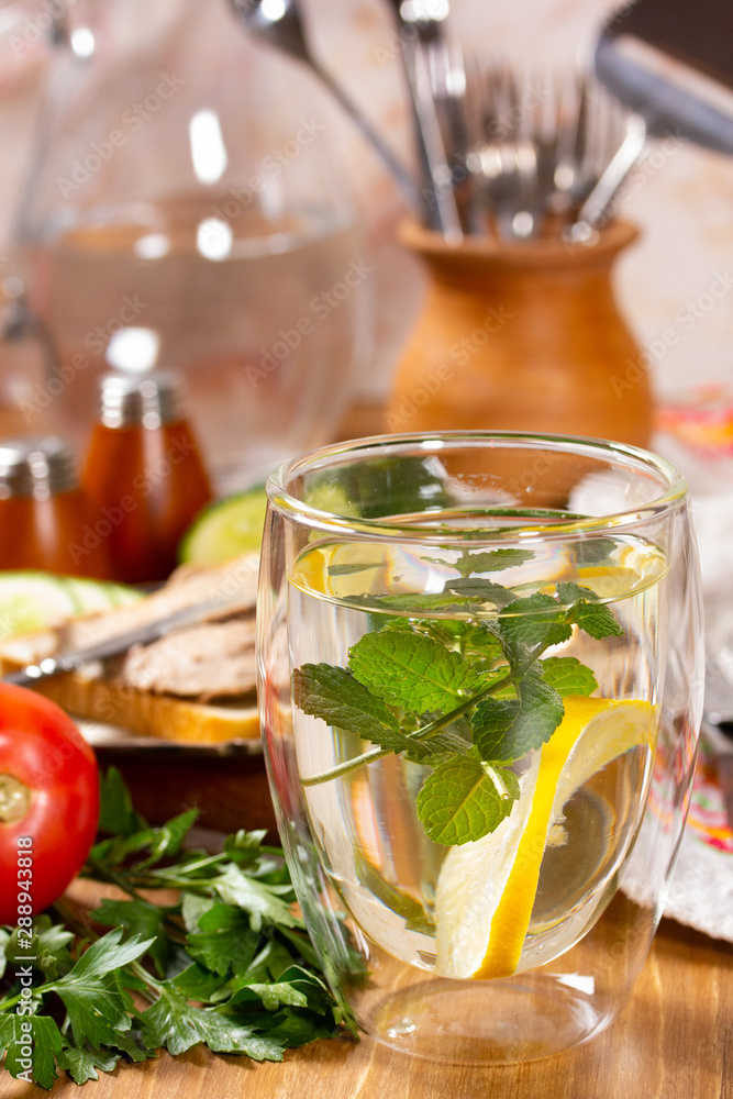 Refreshing drink with lemon and mint in a glass cup
