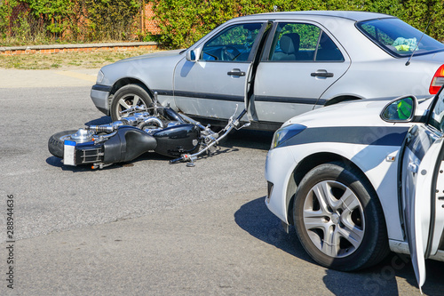 traffic accident, motorcycle collision with a car on city street