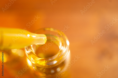Cannabidiol oil (CBD oil) macro background of oil going into a vial