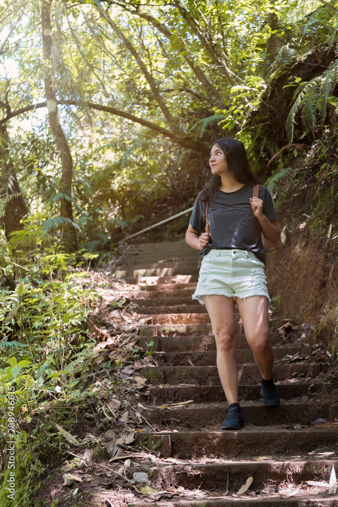 Hispanic traveler walking and exploring in the tropical forest with her backpack on her back- Latin woman traveling in Guatemala
