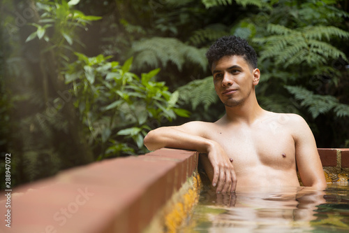 Man relaxing in natural hot springs- man in natural pool in the middle of the forest in Guatemala- Latino man in the spa © Fernanda
