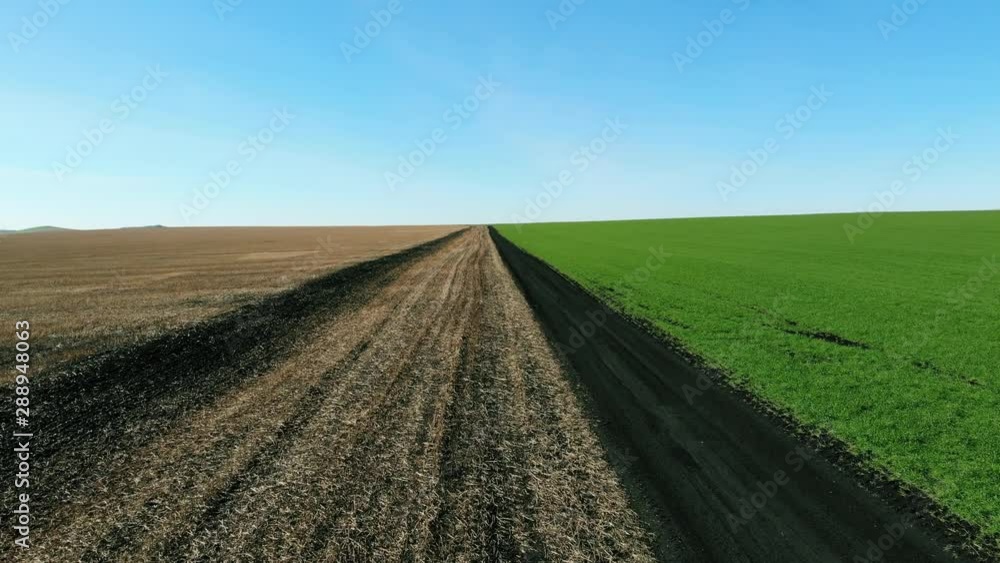 Aerial flight along dirt road between agricultural fields Aerial flight along dirt road between agricultural fields