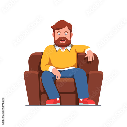 Smiling bearded man sitting on home arm chair