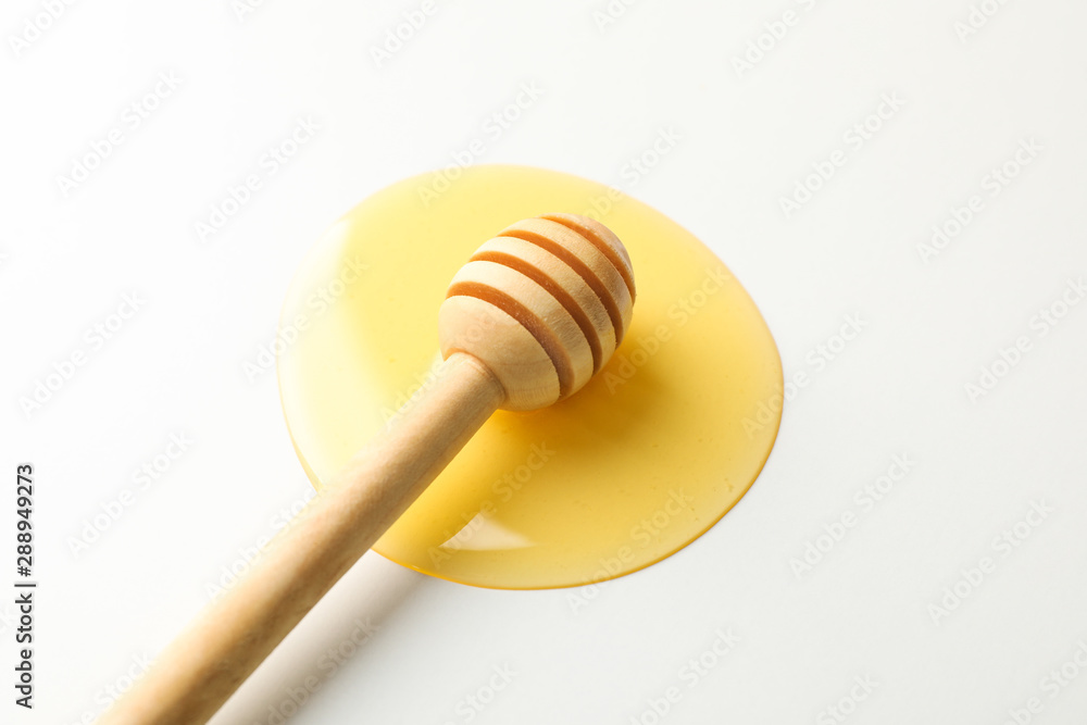 Dipper in puddle of honey on white background, copy space Dipper in puddle of honey on white background, copy space
