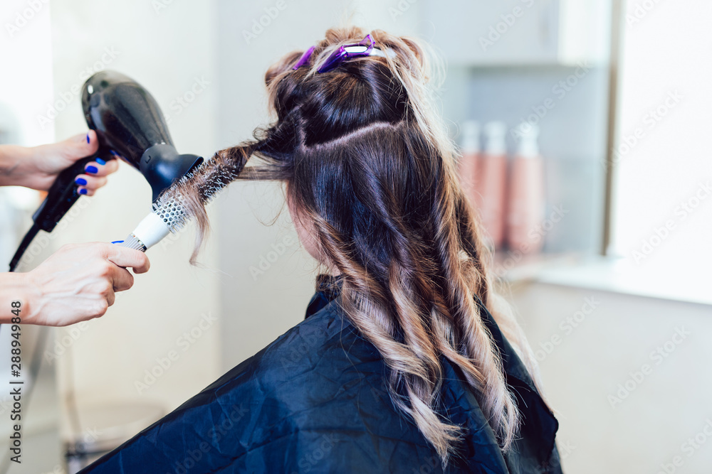 Fototapeta premium Young woman getting beautiful hairstyle in hair salon.