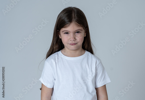 Pretty little girl with a angry facial expression looking mad at the camera. Children emotions