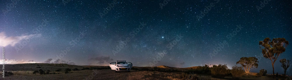 Milky way Panorama and white car in a park