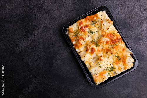 Baked cauliflower in plastic bowl