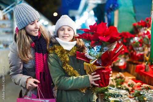 Girl with woman choosing Christmas gifts for family