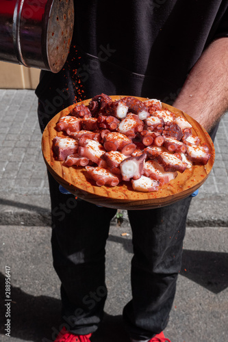 Pulpeiro preparando una ración de pulpo al estilo feira con pimentón. Galicia, España. photo