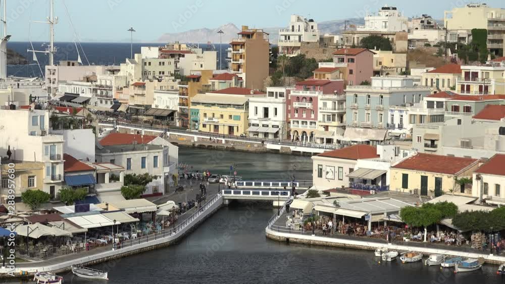 Beautiful sunset at Agios Nikolaos city, Port at Aegean sea. Crete,Greece. Peaceful harbor of Voulismeni Lake. Long promenade with restaurants. Panoramic view of seaport with yachts and boats at quay Beautiful sunset at Agios Nikolaos city, Port at Aegean sea. Crete,Greece. Peaceful harbor of Voulismeni Lake. Long promenade with restaurants. Panoramic view of seaport with yachts and boats at quay
