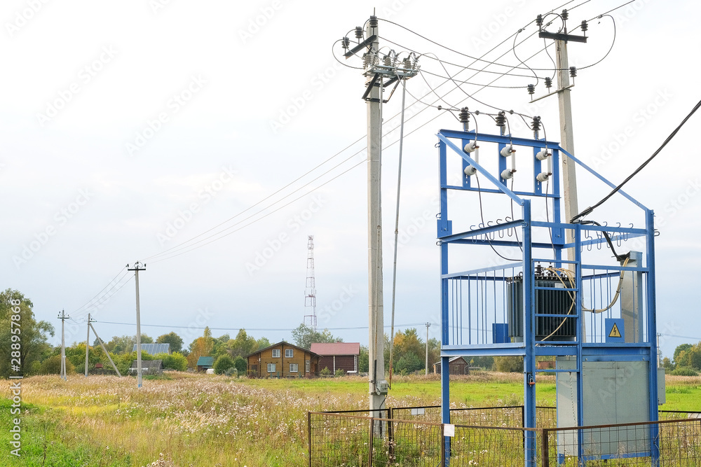 An electric transformer in a field against the backdrop of a private apartment building. An electric transformer in a field against the backdrop of a private apartment building.