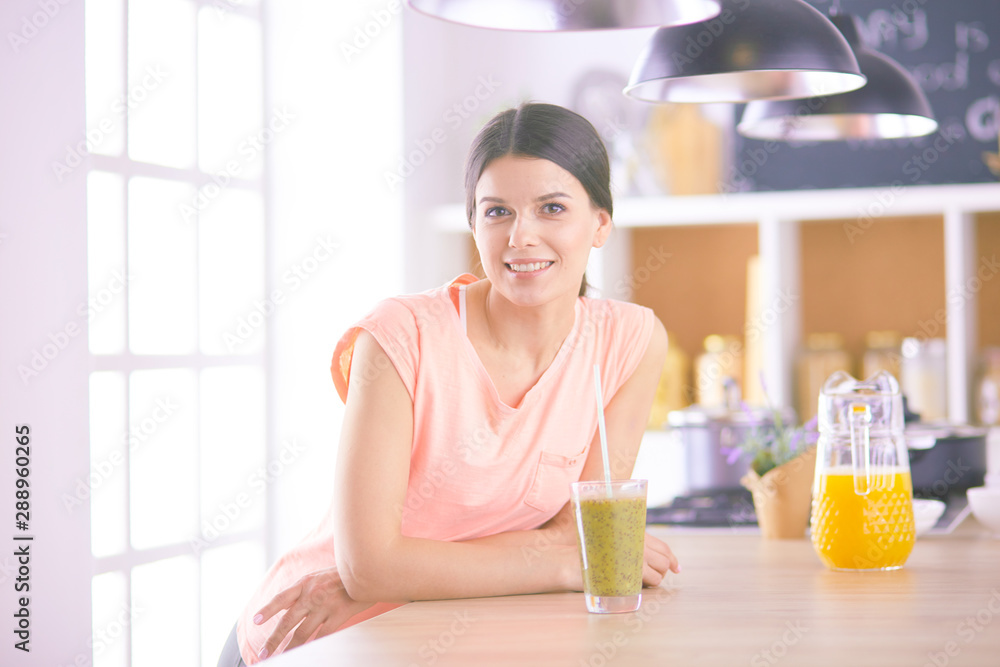 Young woman sitting a table in the kitchen Young woman sitting a table in the kitchen