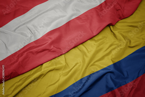 waving colorful flag of colombia and national flag of austria.