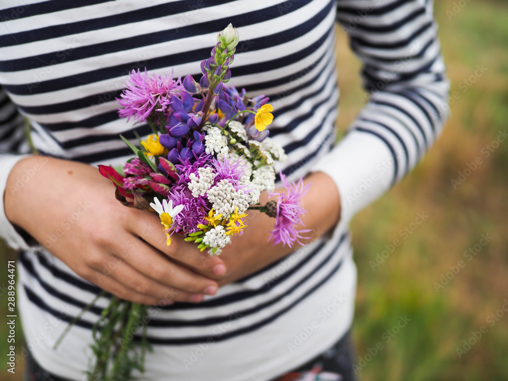 girl holding a bouquet of wild flowers.