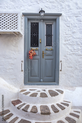 Fototapeta Naklejka Na Ścianę i Meble -  traditional mediterranean door. Entrance door with steps. Narrow traditional white street in the town of Hydra, Hydra island, Greece