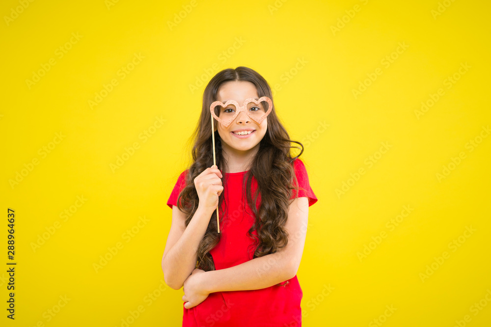 Fototapeta premium Having real fun. prepare for party. happy girl at yellow wall. summer fashion. small girl with party glasses. small girl hold funny glasses. happy birthday. party elements. child ready for party