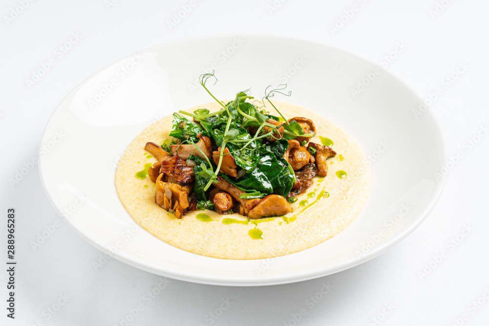 polenta with chanterelles on the white plate polenta with chanterelles on the white plate