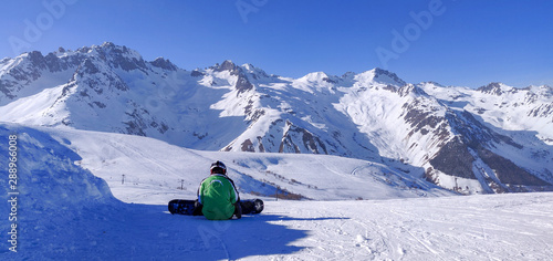 Snowboarder sitting on the mountain 