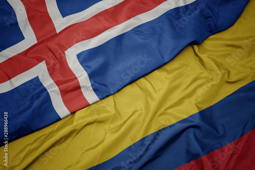 waving colorful flag of colombia and national flag of iceland.