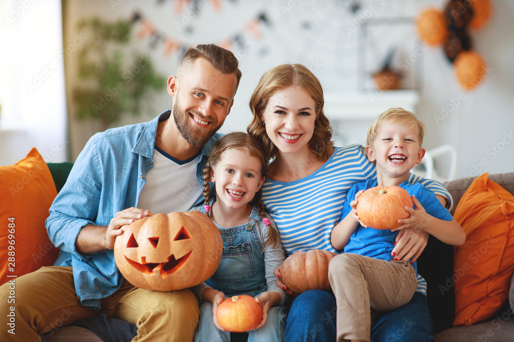 Φωτογραφία happy  family mother father and children prepare for Halloween decorate  home wi