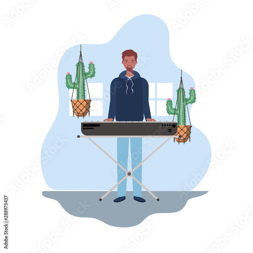 young man with piano keyboard and houseplants on macrame hangers of background
