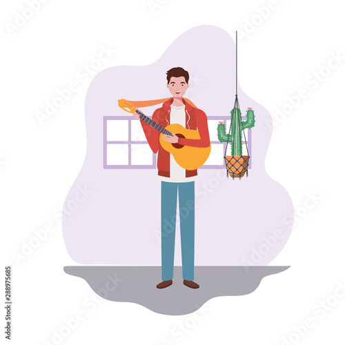 man with acoustic guitar and houseplants on macrame hangers of background