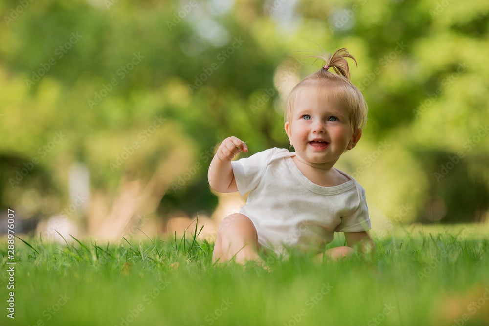 baby girl in a white sandpit on the green grass playing pyramid baby girl in a white sandpit on the green grass playing pyramid
