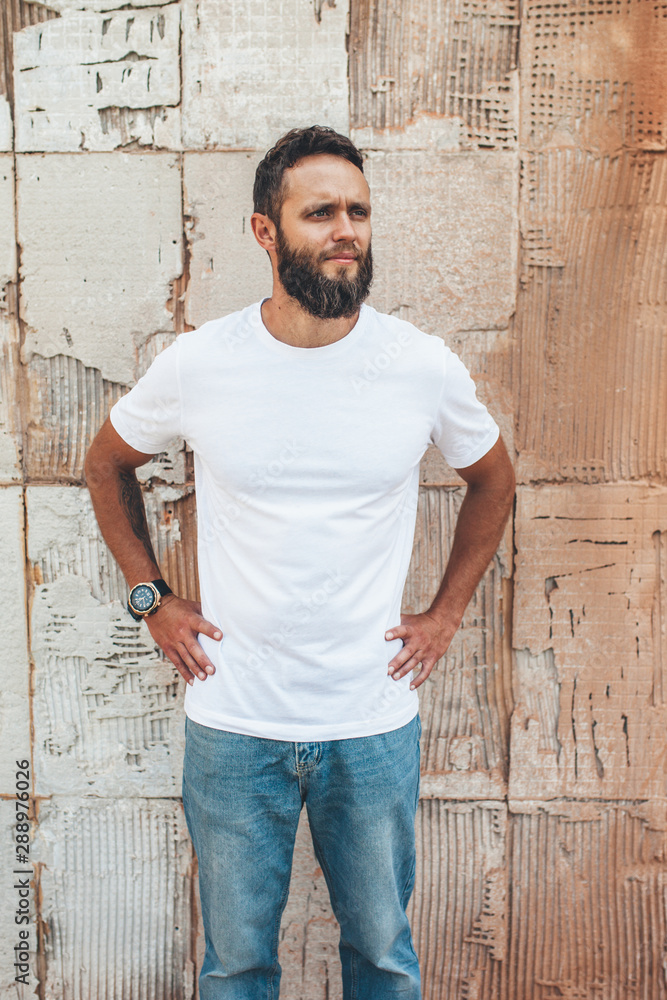 Handsome hipster guy with beard wearing white blank t-shirt with space for your logo or design. Handsome hipster guy with beard wearing white blank t-shirt with space for your logo or design.