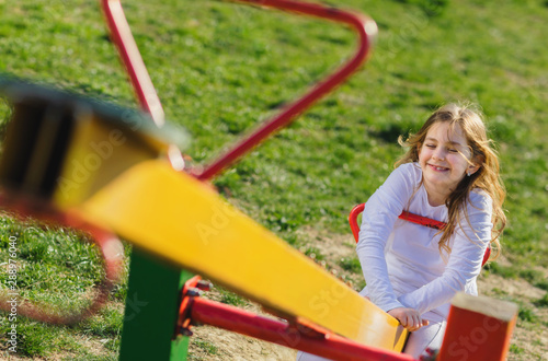 young girl on teeter at playground