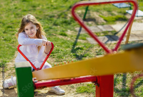 young girl on teeter at playground