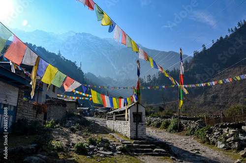 Prayer flags hang along a path in a Nepalese village