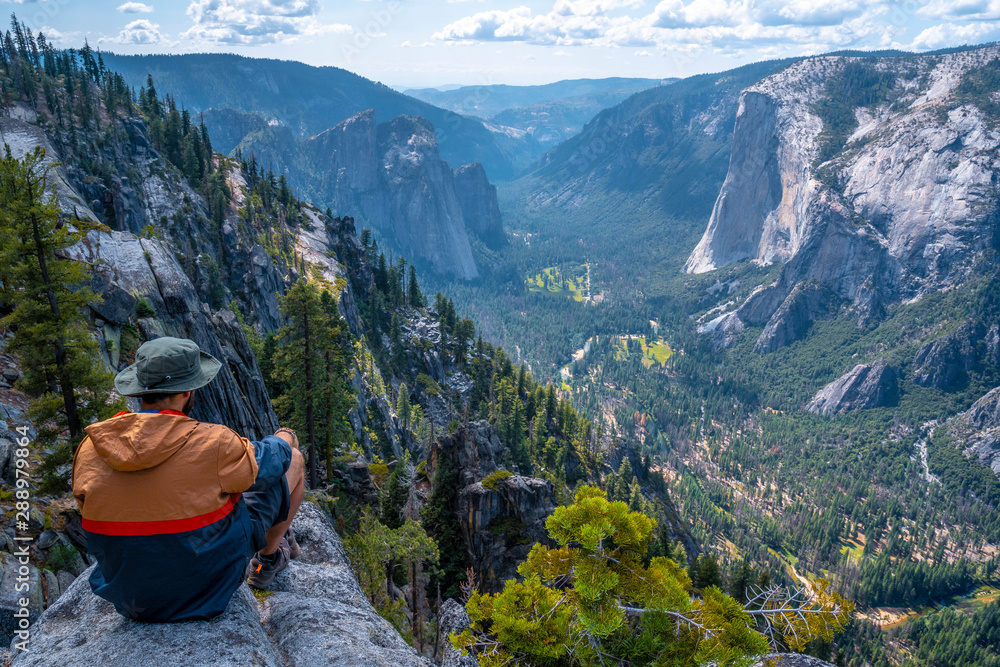 Naklejka premium A young winged seated Taft point looking at Yosemite National Park and El Capitan. United States