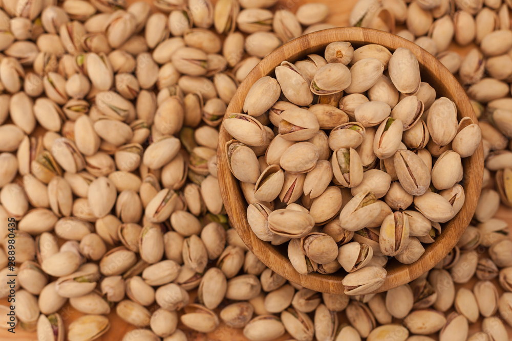 Top view of shell pistachios in wooden bowl