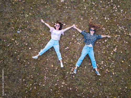 Two girl lying in the grass aerial