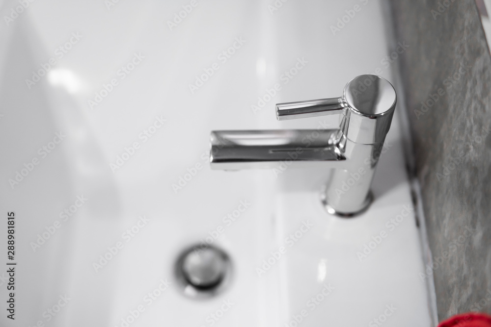 Modern stainless steel faucet with wash basin sink. Counter bathroom interior contemporary. Luxury and stylish design bathroom with a concrete style walls. Modern stainless steel faucet with wash basin sink. Counter bathroom interior contemporary. Luxury and stylish design bathroom with a concrete style walls.