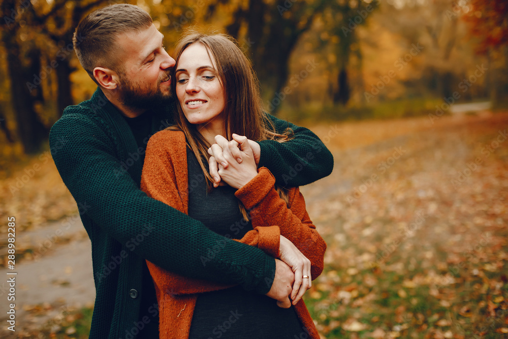 Fototapeta premium Couple in a park. Family in a golden forest. Man with a beard