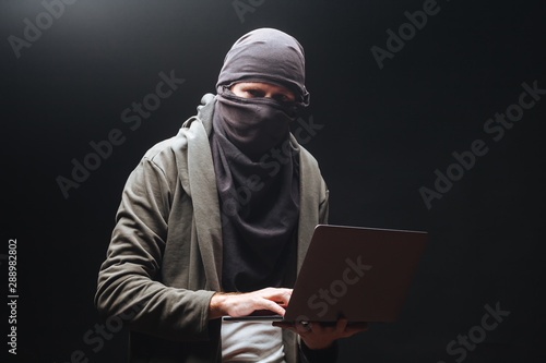 A terrorist with a laptop is preparing a crime at night