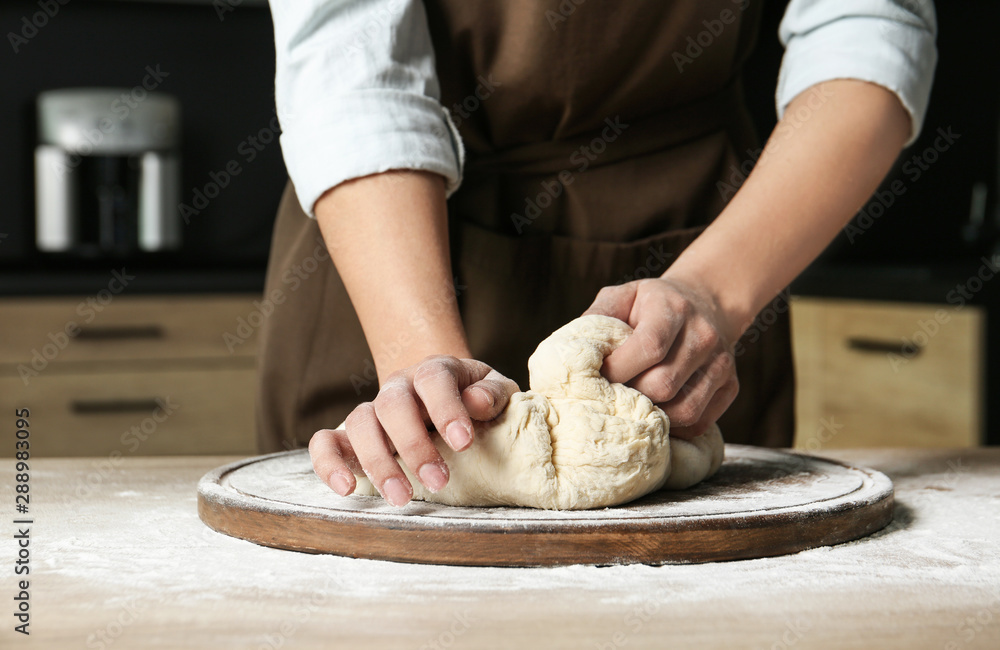 Fototapeta premium Female baker preparing bread dough at table, closeup