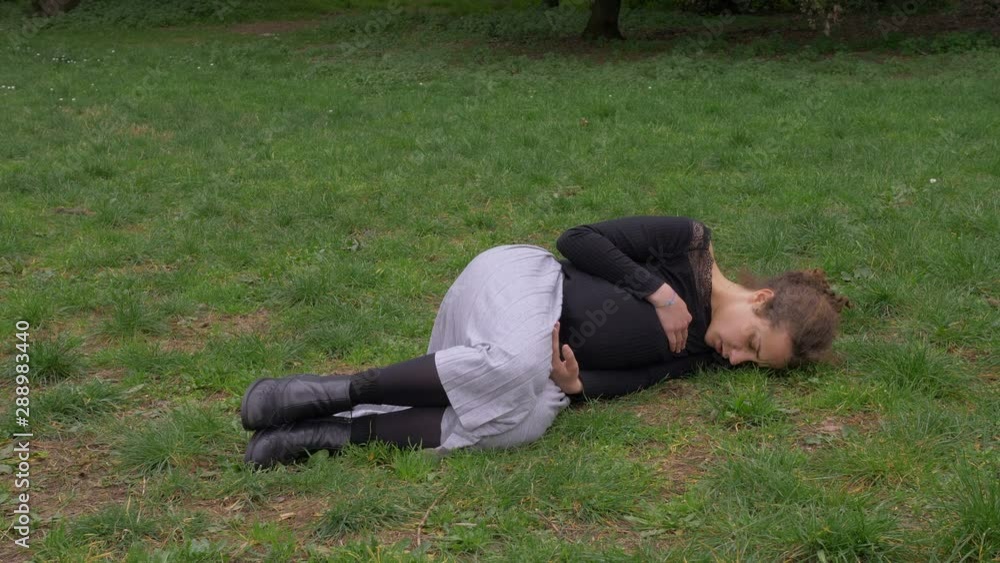 sick drug addict young woman lying alone on the grass. Illness, addiction sick drug addict young woman lying alone on the grass. Illness, addiction